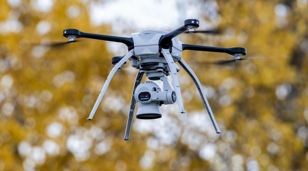 Silueta de un dron militar pequeño sobre un paisaje de frente de guerra; concepto de conflicto contemporáneo entre Ucrania y Rusia
