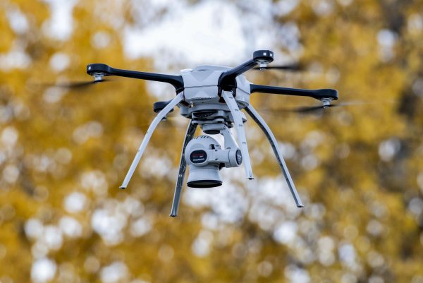 Silueta de un dron militar pequeño sobre un paisaje de frente de guerra; concepto de conflicto contemporáneo entre Ucrania y Rusia