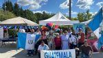 Stand promocional de Guatemala en el Festival Latino de Ottawa con artesanías, imágenes de destinos turísticos y muestra cultural.