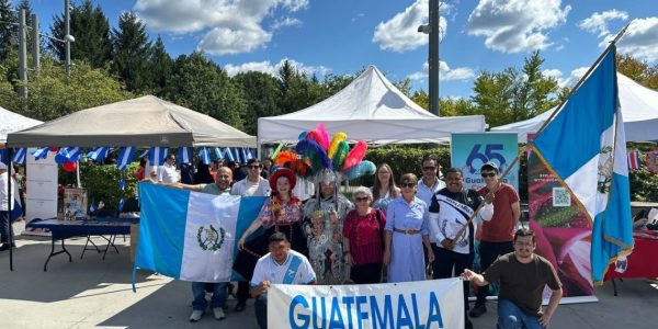 Stand promocional de Guatemala en el Festival Latino de Ottawa con artesanías, imágenes de destinos turísticos y muestra cultural.
