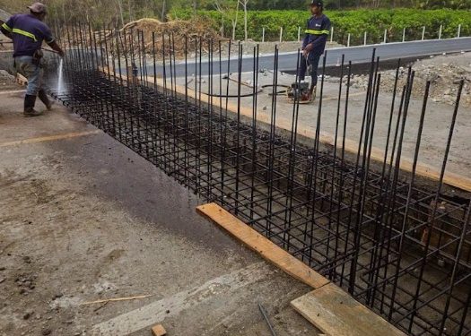 Cuadrillas de trabajo realizando la fundición de las bases de concreto para la instalación del puente Bailey en el sector de Güijo, kilómetro 111 de la CA-9 Norte.