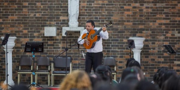 Integrantes del Quinteto Xocomil interactuando con estudiantes durante la presentación de su concierto didáctico.