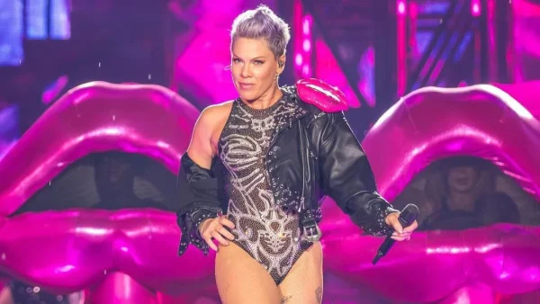 P!nk en un escenario con micrófono, expresión seria, durante un concierto; referencia visual a la polémica con Macklemore y Ed Sheeran por Palestina